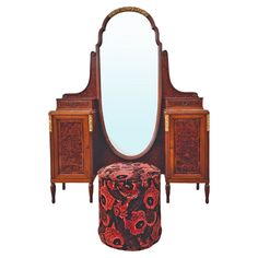 an ornate wooden vanity with mirror and stool