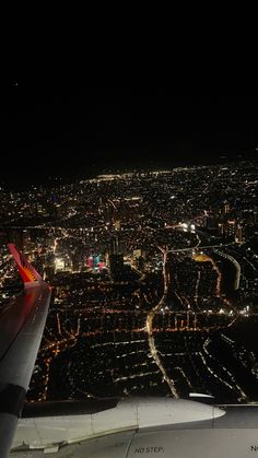 an aerial view of the city lights at night from inside an airplane's window