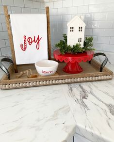 a kitchen counter with a tray, bowl and sign that says joy on it's side