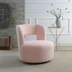 a pink chair sitting on top of a rug next to a vase filled with flowers