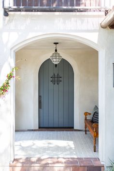 the entrance to a house with a wooden bench