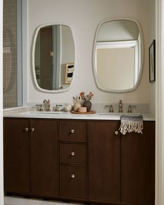 a bathroom with two sinks and mirrors on the wall