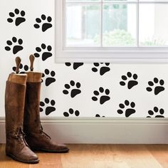 a pair of boots sitting on top of a hard wood floor next to a window