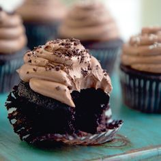 chocolate cupcakes with frosting and sprinkles on a blue tray