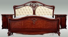 a wooden bed with an ornate headboard and foot board on top of the bed