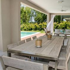 a wooden table sitting under a window next to a swimming pool