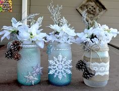 three mason jars filled with white flowers and pine cones