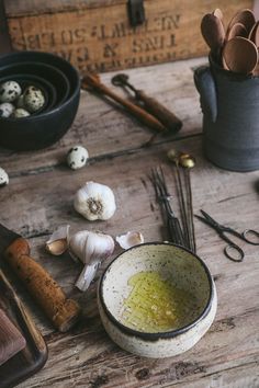 an assortment of cooking utensils on a table with garlic and cloves