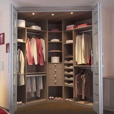 an open closet with clothes and shoes in it