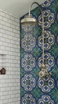 a shower head and hand held shower faucet in front of a tiled wall