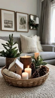 a basket filled with christmas decorations and lit candles sitting on top of a coffee table