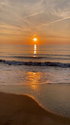 the sun is setting over the ocean with waves