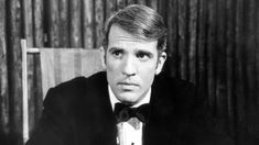 a man in a tuxedo sitting at a table