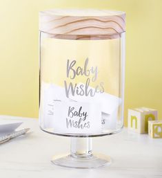 a clear glass container with baby wishes written on it