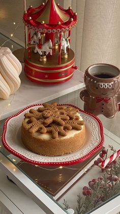 a cake on a red and white plate next to a cup of coffee with a carousel in the background