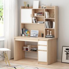 a computer desk with books and other items on it in a white room next to a window