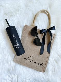 a tote bag and sunglasses on top of a white furnishing with the name ananuka written on it