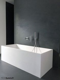 a large white bath tub sitting next to a wall mounted faucet in a bathroom