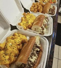 four takeout containers with different types of food in them on a counter top,