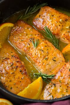 salmon with oranges and herbs in a pan