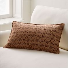 a brown pillow sitting on top of a white couch