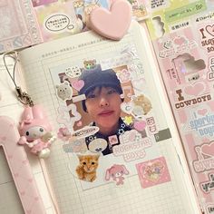 an open notebook with stickers and keychains attached to the pages, featuring a photo of a woman's face