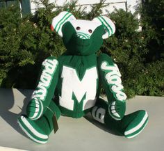 a large green and white teddy bear sitting on top of a table