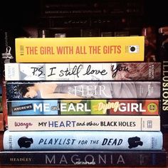 a stack of books sitting on top of each other in front of a book shelf