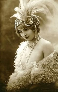 an old fashion photo of a woman with feathers on her head