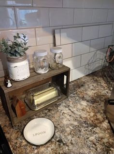 a kitchen counter with a white plate on top of it and some jars next to it