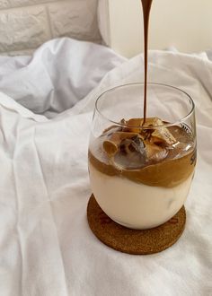 an ice cream sundae is being drizzled with chocolate