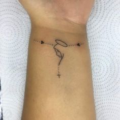 a woman's wrist with a small tattoo on the left side of her arm