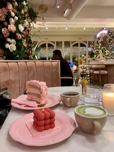 a table with plates and cups filled with cake on top of each plate next to a candle