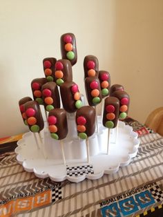 there are many candy lollipops on the stick in the cake plate and it is ready to be eaten