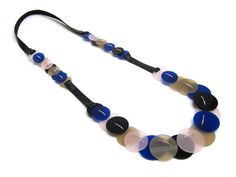 This long necklace is a handmade piece crafted with acrylic and elastic fabric. It features a series of circles in a mix of colors: blue, beige, transparent, and black. The combination of these colors and materials gives the necklace a modern and versatile look, with a playful mix of opaque and translucent elements. Its lightweight and flexible design make it comfortable and easy to wear, adding a unique and stylish touch to any outfit. Flexible Design, Elastic Fabric, Wedding Jewellery Necklace, Lovely Necklace, Accessories Unique, Wedding Necklace, Statement Jewelry, Long Necklace, Circles