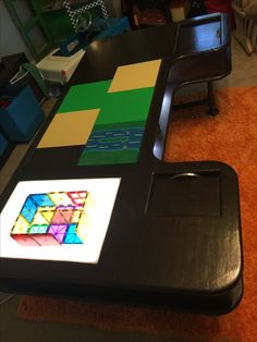 a table that has some kind of colorful object on top of it and is in the middle of an orange carpeted room