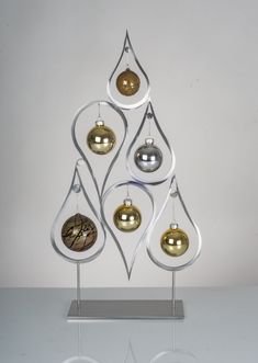 an ornament shaped christmas tree with gold and silver ornaments hanging from it's sides