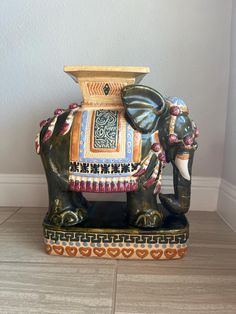 an elephant statue sitting on top of a tile floor