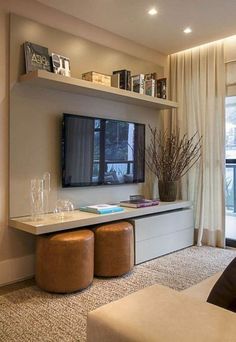 a living room filled with furniture and a flat screen tv mounted on a wall next to a window