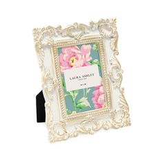 a white frame with pink flowers on it and a name tag hanging from the front