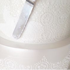 a knife sticking out of the side of a white dress with intricate lace on it