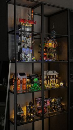 a display case filled with lots of different types of toy buildings and lights on top of it