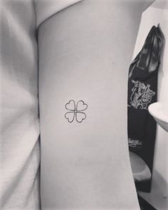 a woman with a tattoo on her arm that has four leaf clovers on it