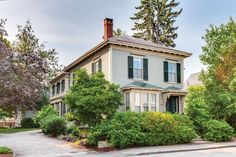 a house with trees and bushes in front of it