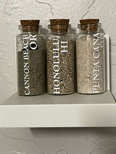 three jars with different types of spices on a shelf