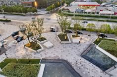 an aerial view of a city square with trees and plants