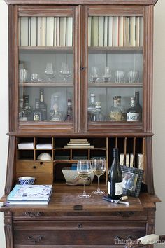 an old wooden cabinet with wine glasses on it