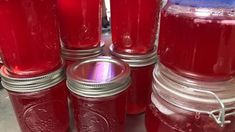 several jars filled with red liquid sitting on top of a table