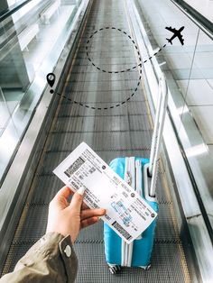 a person is holding a ticket and standing on an escalator