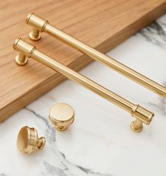 two golden handles and knobs on a marble counter top